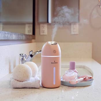 a pink portable humidifier on a counter in a bathroom