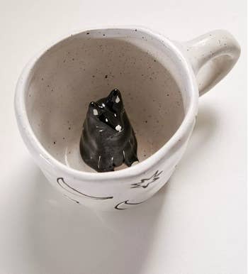 Small white moon pattern mug with a cat in it 
