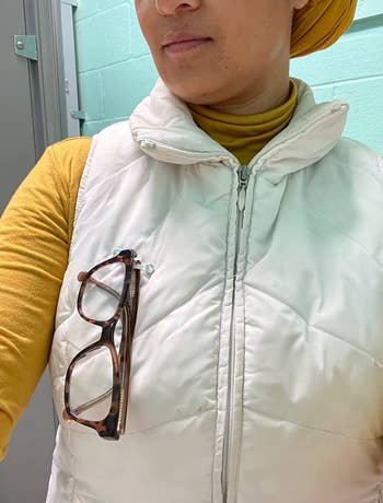 reviewer with the glasses clipped to a puffer vest 