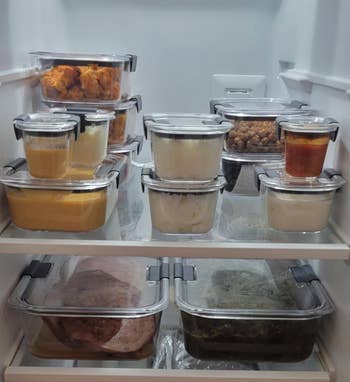 Organized fridge shelves with glass containers holding various foods, including leftovers and sauces, suitable for meal prep or storage