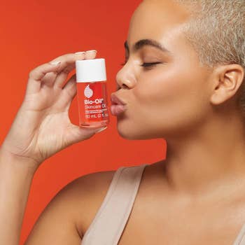 Person kissing and holding a bio-oil container