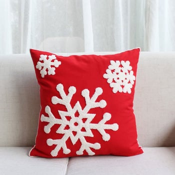 a pillow with the red embroidered snowflake cover