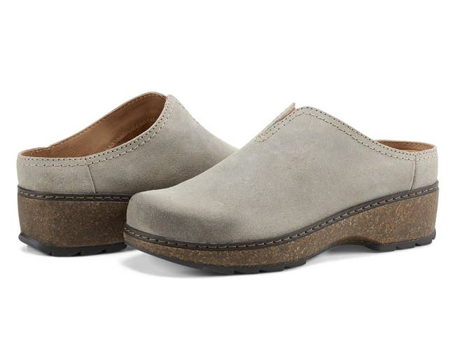 two grey suede slip-on clogs with cork-like level soles against a achromatic background