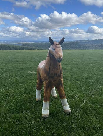 A blow up horse sitting on a lawn 