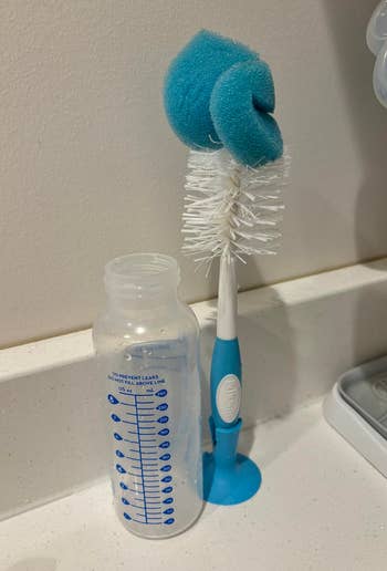 Baby vessel and cleaning brushwood with a sponge extremity connected a countertop