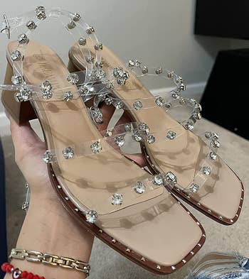 Reviewer holding clear strappy heels