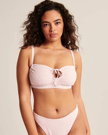 model wearing pink gingham bathing suit top with a keyhole and drawstring design
