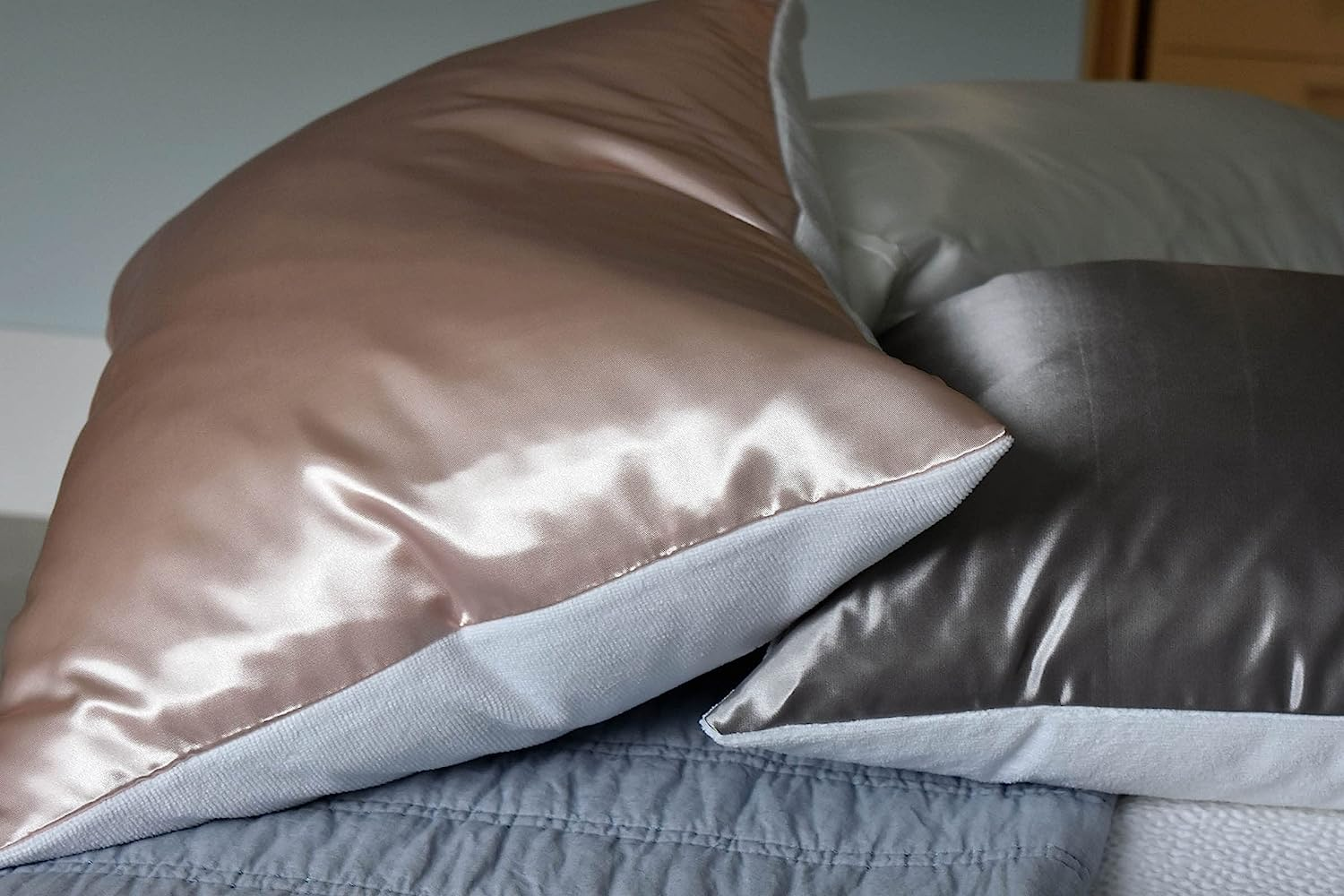a side view of the pink and gray satin pillows