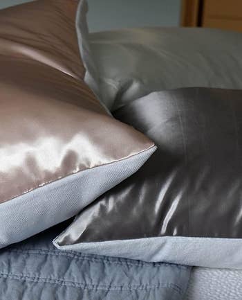 a side view of the pink and gray satin pillows