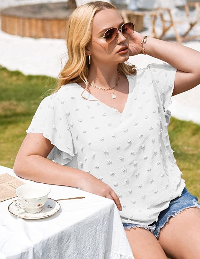 a model wearing the white pom pom top