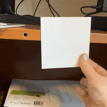 A gif of a reviewer sticking the post it to a surface and then removing it