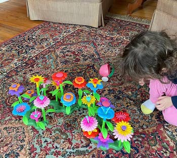 another reviewer's child playing with the colorful plastic flowers