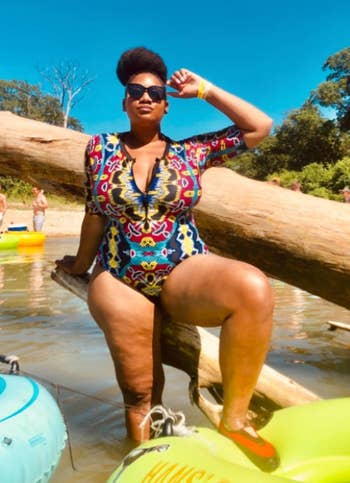 reviewer wearing the short-sleeved zip-front swimsuit in a multicolored graphic pattern