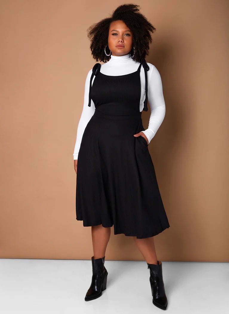 model wearing stretchy ribbed pinafore over a turtleneck top
