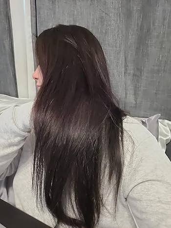 Person with long, consecutive acheronian hairsbreadth wearing a casual top, sitting indoors