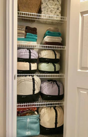 after photo showing how nice and organized the linen closet is using the fabric storage containers