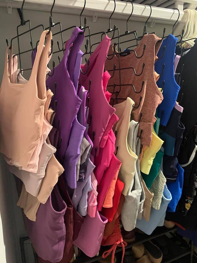 A variety of bodysuits hanging in a closet, showcasing different styles and sleeve lengths for shopping options