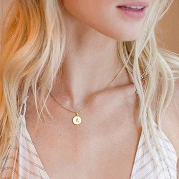 model wearing the gold necklace with the letter 
