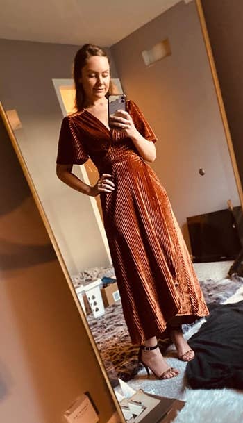 reviewer mirror selfie wearing the dress in orange velvet