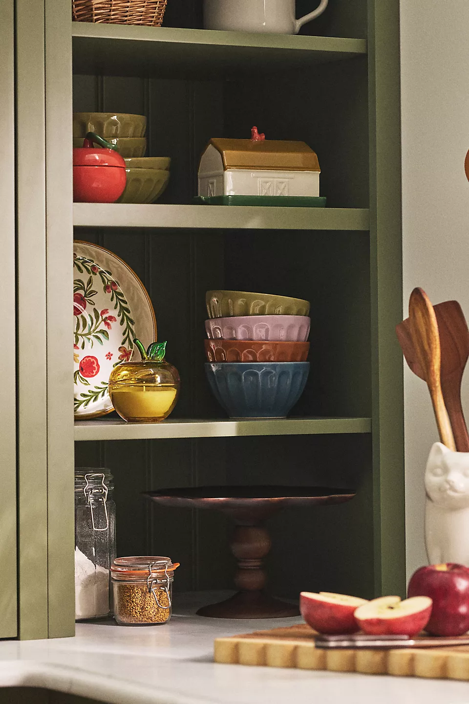 Kitchen support  with neatly stacked bowls, a decorative plate, containers, and woody  utensils. A cozy, organized mounting  for location  and room  shopping