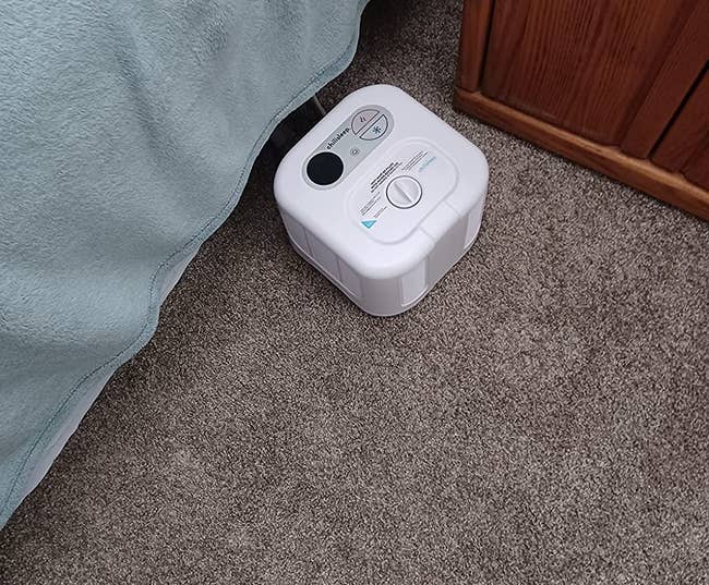 a reviewer photo of the ChiliSleep cube next to a bed 