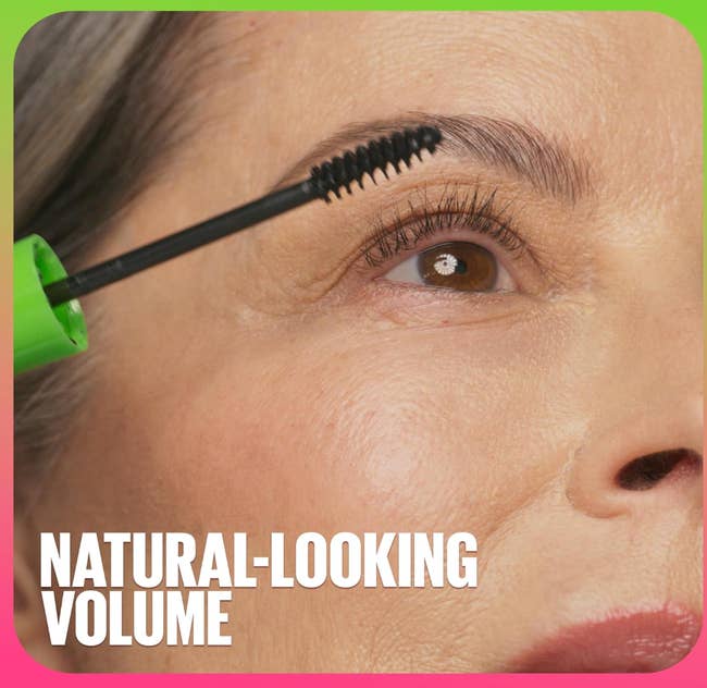 Close-up of a mature pistillate   applying mascara with absorption   connected  her eyelashes; substance   reads, 