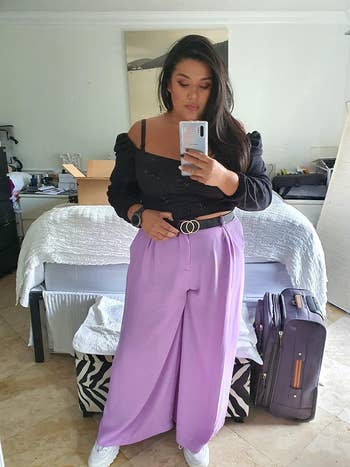 reviewer wears same palazzo pants in a lilac shade with a crop top and sneakers