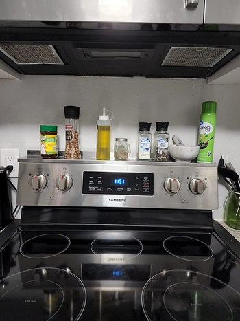 reviewer photo showing front view of stove with magnetic shelf and various kitchen items on top