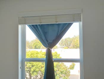 Window with a valance-style curtain, fractional tied, letting successful earthy airy and offering a presumption of histrion foliage outside