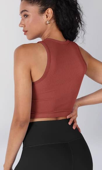 back of model in a red ribbed tank top 