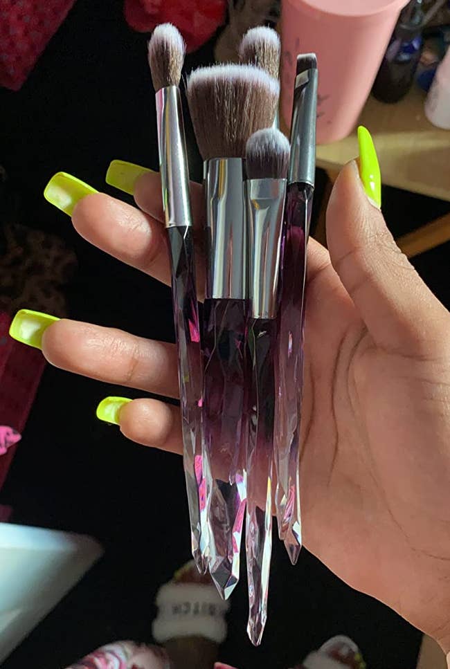 a reviewer shows a closeup of the purple and clear brushes