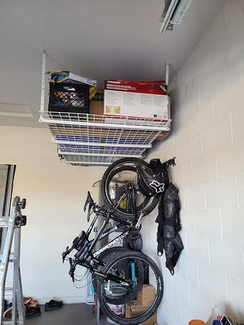 reviewer's achromatic  ceiling equine   shelves installed successful  store  holding boxes and different   items with motorcycle  rack connected  partition  nether  it