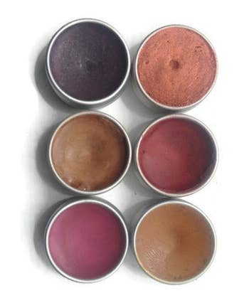 six tins of makeup in various shades