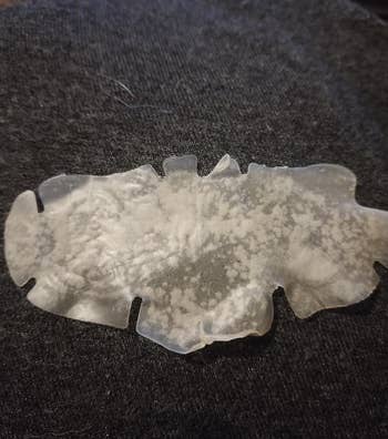 a reviewer photo of a used nose strip with gunk on it 