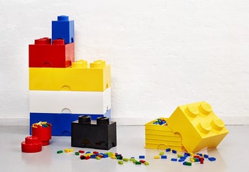 lifestyle image of colorful LEGO brick shaped storage bins, stacking, full of LEGOs