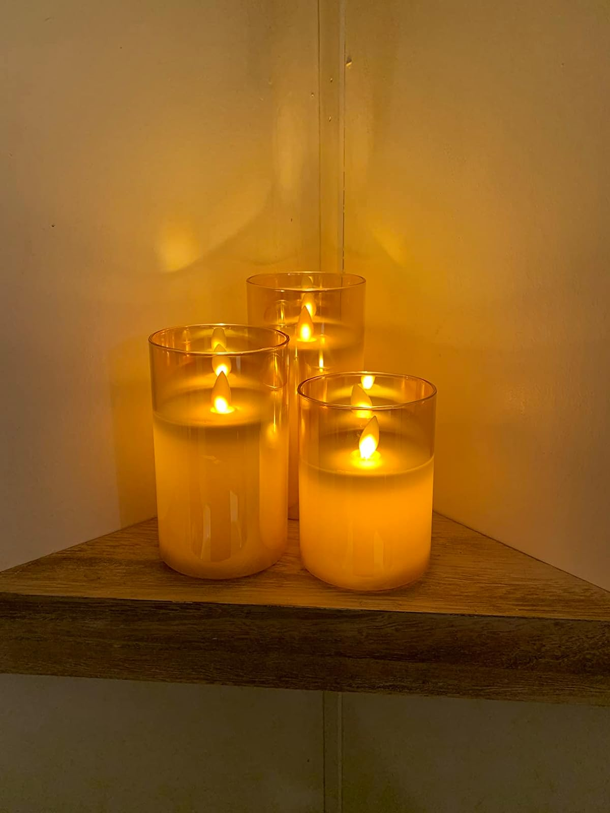 a set of three flameless candles in clear glass cylinders