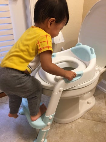 reviewer image of a child climbing the step stool onto a toilet