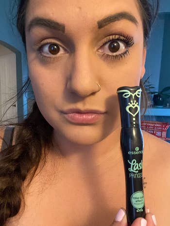 reviewer holding mascara and with mascara on one eye