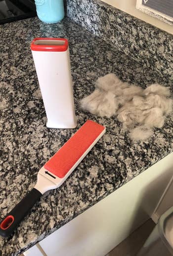 the lint brush on a reviewer's counter next to the base and a pile of fur