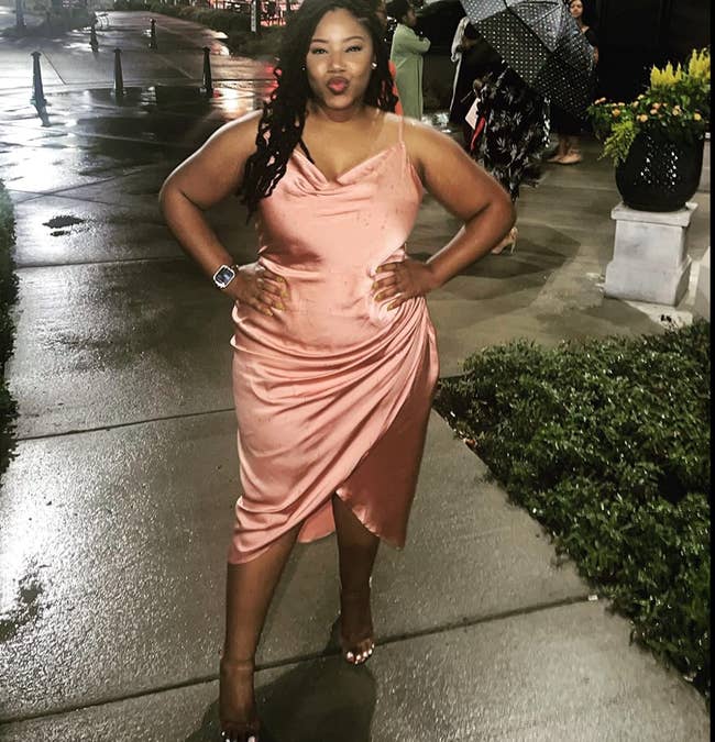 reviewer wearing cowl neck satin dress in a pink shade