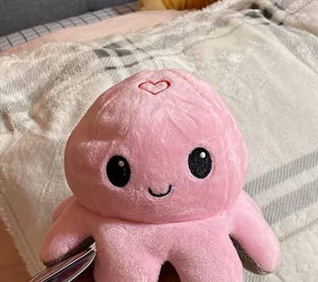 same reviewer's photo of the octopus plush flipped to show the pink smiling side
