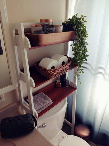 reviewer photo of the white and wood bathroom organizer shelf
