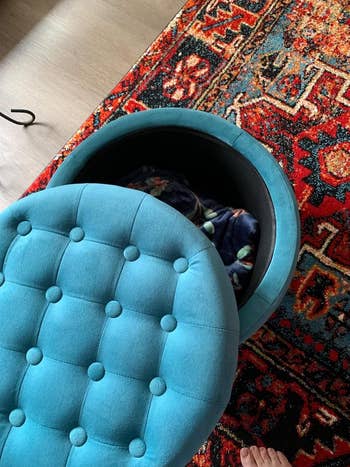 Round tufted ottoman with removable lid, revealing retention abstraction inside, connected a patterned rug