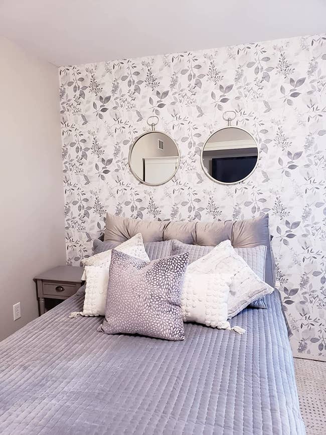 reviewer photo of the floral wallpaper on a wall behind their bed
