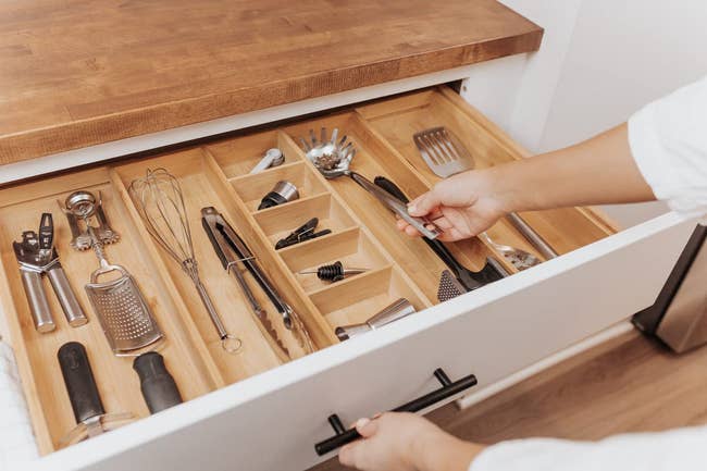 model opening drawer showing the adjustable organizer holding various kitchen utensils