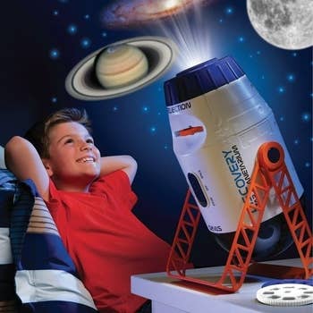Kid looking up at ceiling full of space projections