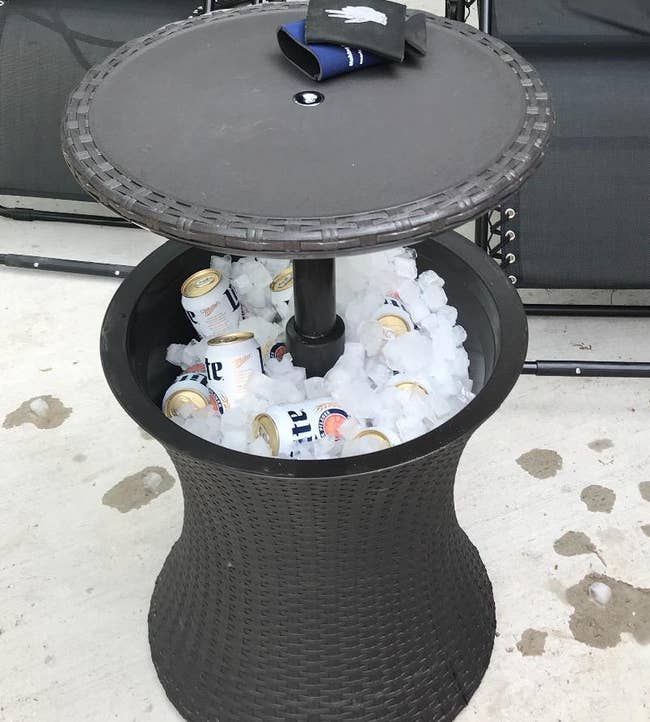 reviewer photo of the side table cooler filled with ice and cans of beer