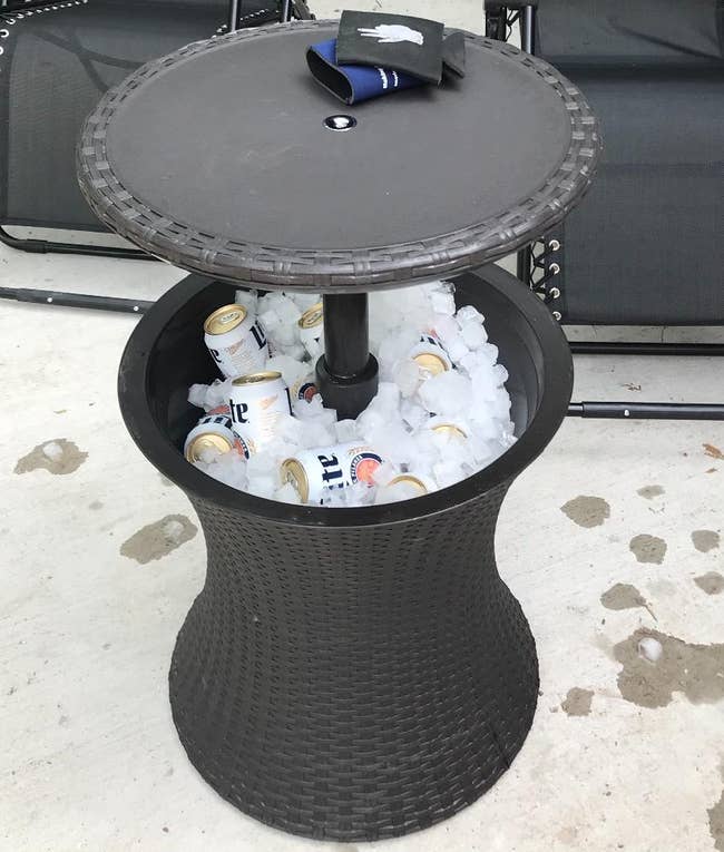 The side table cooler filled with ice and cans of beer