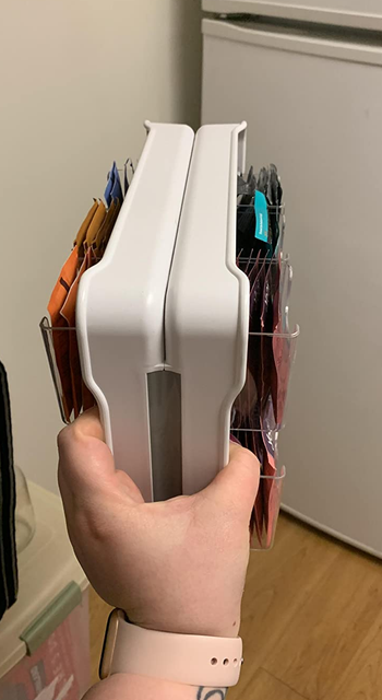 reviewer holding the tea stand packed with tea bags to show how thin it is