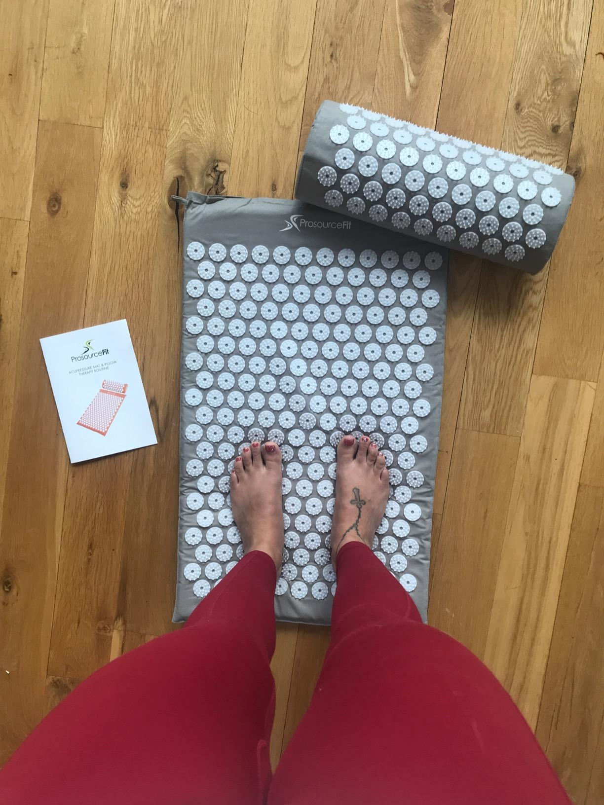 a reviewer standing on the acupressure mat and in gray 